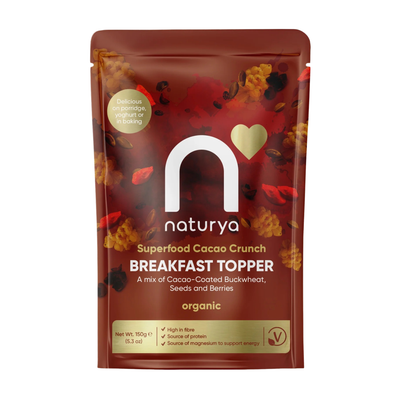 A stand-up pouch of Naturya Breakfast Topper organic superfood cacao crunch, featuring a dark red and brown design with scattered cacao pieces and a gold heart logo.